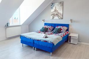 - un lit bleu dans une chambre avec la tour eiffel dans l'établissement Apartments Wyszyńskiego, à Szczecin