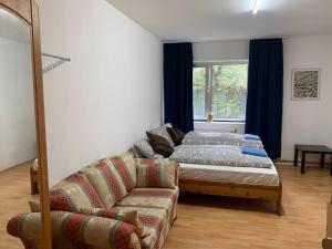 ein Wohnzimmer mit einem Bett und einem Sofa in der Unterkunft FischersPension in Ahrensburg