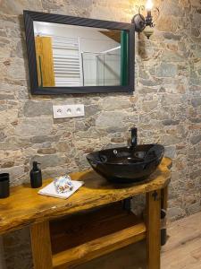 La salle de bains est pourvue d'un lavabo noir et d'un miroir. dans l'établissement Apartmán Elenka, à Zuberec