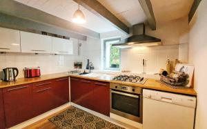 a kitchen with brown cabinets and a stove top oven at ArT Home Maison d'artiste in Honfleur
