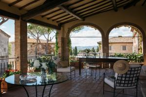 a patio with a table and chairs and a piano at Borgo San Felice in Castelnuovo Berardenga