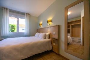 a bedroom with a large bed and a large mirror at Hôtel LES TERRASSES in Le Verdon-sur-Mer