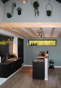 una cocina con encimeras negras y fregadero en Hoeve Altena Cottage, en Woudrichem