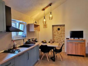 een keuken met een wastafel en een tafel met stoelen bij Vacation house Punta sunca in Stari Grad