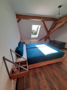 ein Schlafzimmer mit einem blauen Bett im Dachgeschoss in der Unterkunft Ferienwohnung Kunst und Kulturschuppen Hasenmühle in Kammerstein