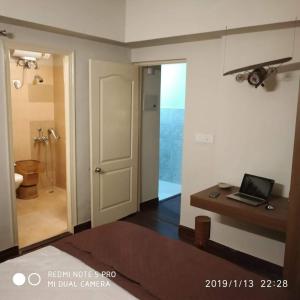 a room with a bathroom with a laptop on a desk at Independent Charming Studio with balcony Urban view in Noida