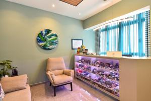a waiting room with a chair and a cabinet filled with stuffed animals at Hotel Apartamento Bajamar in Las Palmas de Gran Canaria