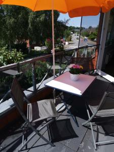 einen Tisch und Stühle auf einem Balkon mit Sonnenschirm in der Unterkunft Ferienwohnung "Zur Biene" in Winsen
