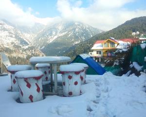 a view of a snowy mountain with a tent and tents at Hotel Victoriya palace in McLeod Ganj