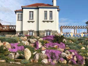 a house on top of a hill with flowers at Chalet O Amorzinho Sintra Praia in Sintra