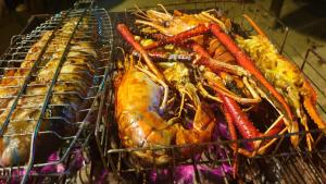 a rack of food with a lobster and other foods at Happy Cocos Beach House in Waskaduwa