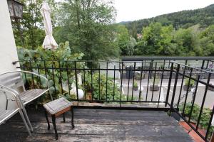 a balcony with a bench and an umbrella and a river at Baderhaus in Bruck an der Mur