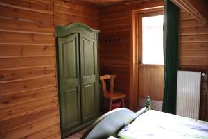 a bedroom with a green cabinet and a bed at Holzhaus am Silbersee in Frielendorf