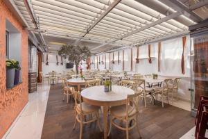 eine Reihe von Tischen und Stühlen in einem Restaurant in der Unterkunft Habitat Hotel in Kilkís