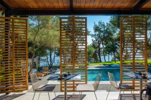 a patio with tables and chairs and a pool at Elies 33 Bio Retreat in Afitos