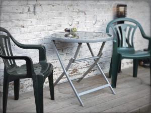 a table and two chairs next to a brick wall at Richmond Luxury flat Fabulous location in Southend-on-Sea