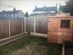 a backyard with a wooden fence and a shed at Richmond Luxury flat Fabulous location in Southend-on-Sea