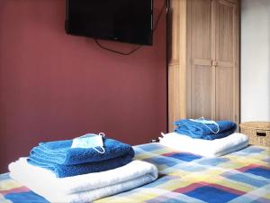two piles of towels sitting on a bed with a television at Richmond Luxury flat Fabulous location in Southend-on-Sea