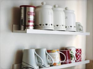 a shelf with cups and other items on it at Richmond Luxury flat Fabulous location in Southend-on-Sea
