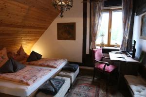 a bedroom with two beds and a desk and a window at Baderhaus in Bruck an der Mur