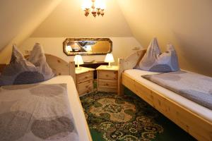 a attic bedroom with two beds and a mirror at Baderhaus in Bruck an der Mur