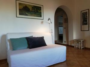 un letto bianco in una stanza con lampada di Le civette a Montecatini Val di Cecina