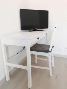 a white desk with a television on top of it at La Casa del Purpaiolo in Favignana
