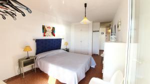 een slaapkamer met een bed met een blauw hoofdeinde bij Rocamaura II 2 8 inmoestartit in L'Estartit +14 foto's