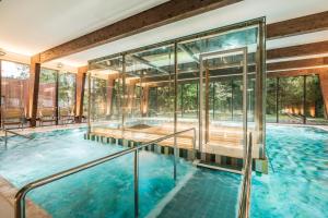 an indoor swimming pool with glass walls at Wasa Resort Hotel, Apartments & SPA in Pärnu