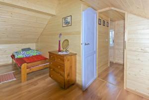 1 dormitorio con 1 cama y suelo de madera en niezapominajka-jura, en Niegowa