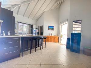 a kitchen with blue cabinets and bar stools at La villa de Christian in Baie-Mahault