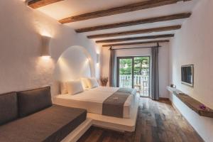 a bedroom with a bed and a couch and a window at Flamingo Hotel & Spa - Pet Friendly in Oludeniz