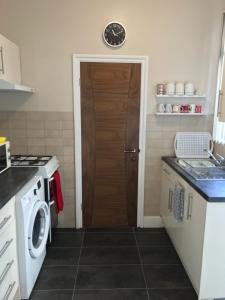 a kitchen with a washing machine and a door at Richmond Luxury flat Fabulous location in Southend-on-Sea