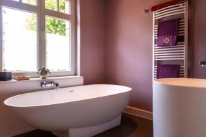 a white bath tub sitting next to a window at B&B Saint-Georges in Bruges