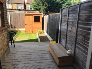 a wooden deck with a bench and a fence at Richmond Luxury flat Fabulous location in Southend-on-Sea