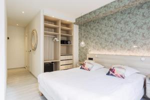 a bedroom with a white bed with two pillows on it at Beach Hotel Helios by CW Hotel Collection in Blankenberge