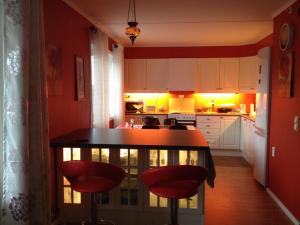 uma cozinha com paredes vermelhas e uma mesa com bancos vermelhos em Sleep well 1 em Kongsberg