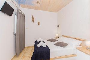 a white bedroom with a bed with towels on it at Peristeronas Village in Klouvas