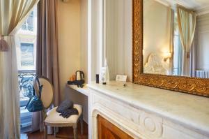 Hôtel Vaubecour في ليون: مرآة جالسة على رأس موقد في غرفة
