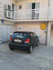 a car parked in front of a white house at Apartments Kresic in Hvar