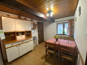 eine Küche mit weißen Schränken und einem Tisch in der Unterkunft Gite Lammer in Artolsheim