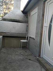 a chair sitting next to a building with a stove at Apartments Kresic in Hvar