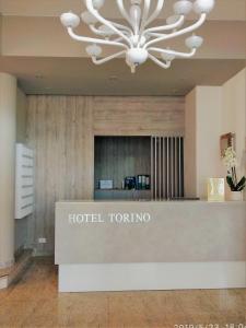 リド・ディ・イエゾロにあるHotel Torinoのシャンデリアのあるホテル東京ロビー