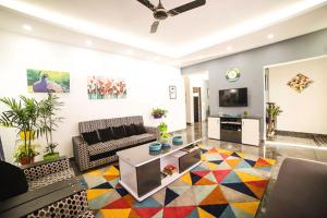 a living room with a couch and a tv at Villa Tesori Homestay Wayanad in Meppādi