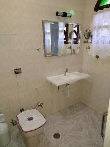 a bathroom with a sink and a toilet at Casa linda e confortável a 3 min da praia!!! in Peruíbe
