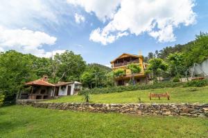 una casa en una colina con un banco delante en Guest House Villa Teres, en Shipka