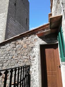 un edificio in mattoni con una porta in legno e una torre di Le civette a Montecatini Val di Cecina