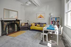 图克斯伯里The Old Stocking Factory, Tewkesbury的客厅里有一张桌子和一张黄色沙发