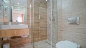 a bathroom with a shower and a toilet and a sink at Monarch House in Braşov