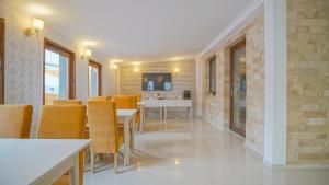 a dining room with yellow chairs and a table at Monarch House in Braşov